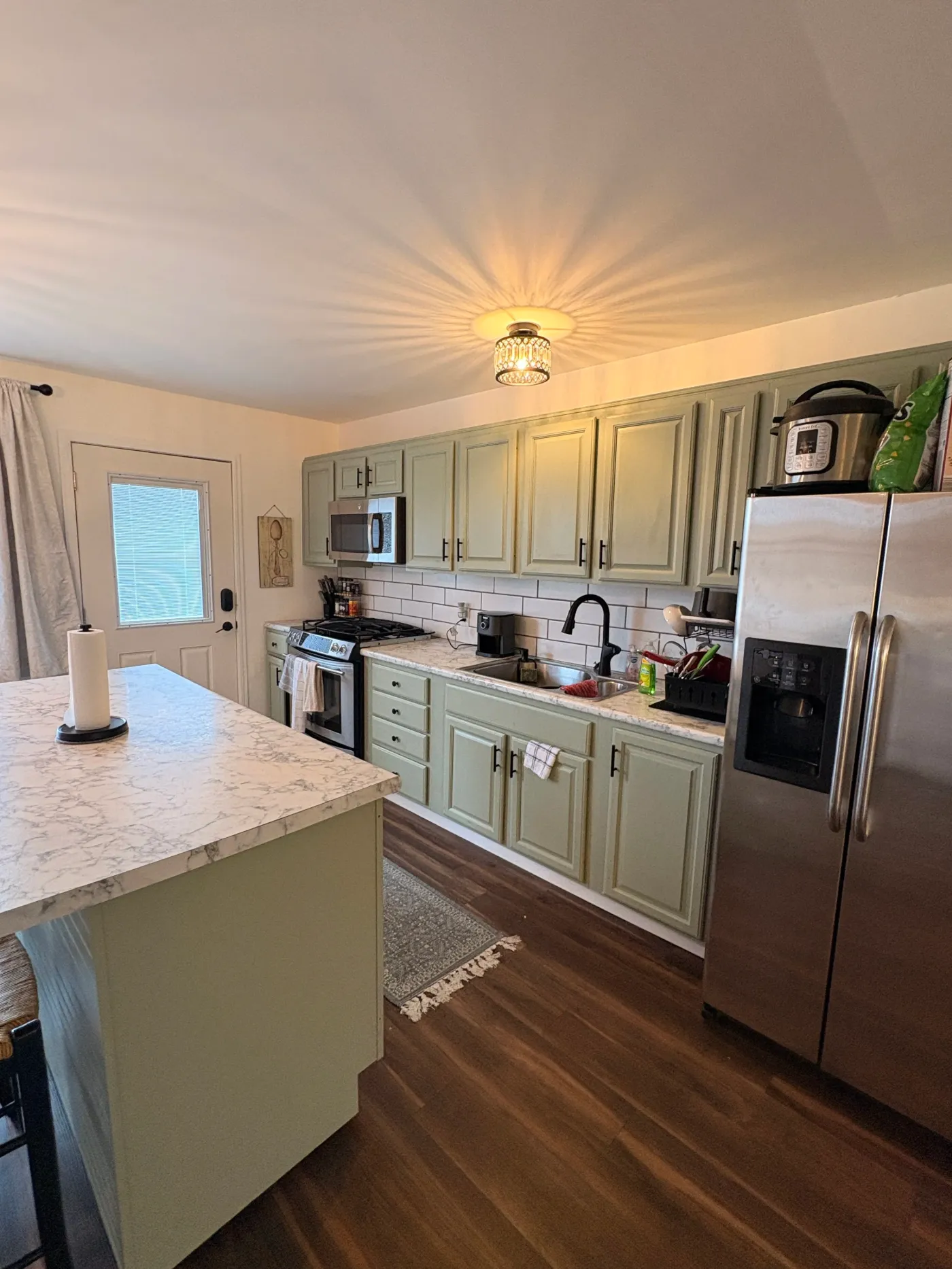 Bright kitchen with green cupboards at Casa Bella in Allendale